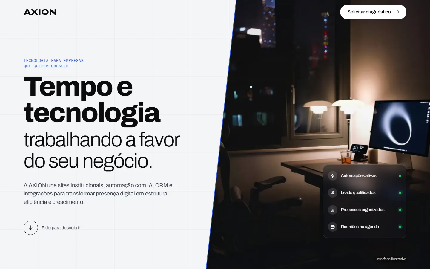 Página inicial do site da AXION: foto noturna de uma mesa de trabalho diante da janela, com o título “Tempo e tecnologia trabalhando a favor do seu negócio.”
